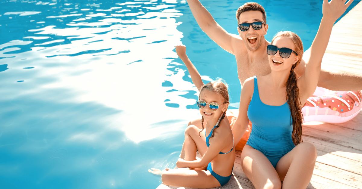 Happy family enjoying time by a blue pool